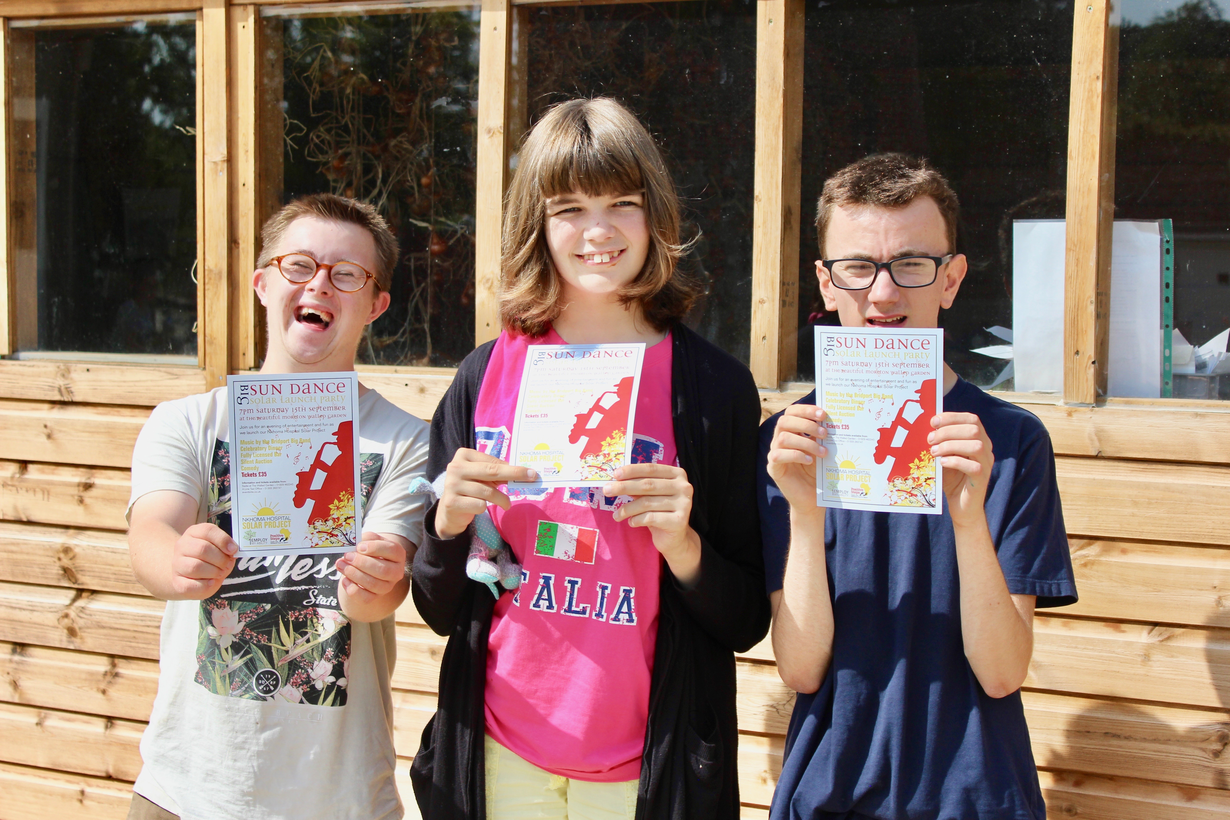 Three EMA Moreton Students holding up Big Sun Dance Solar Launch Party posters.