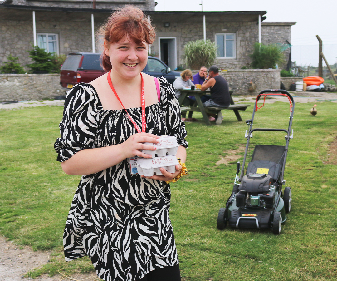 Business & Partners Promotional Photos: One student doing moving free range egg boxes..