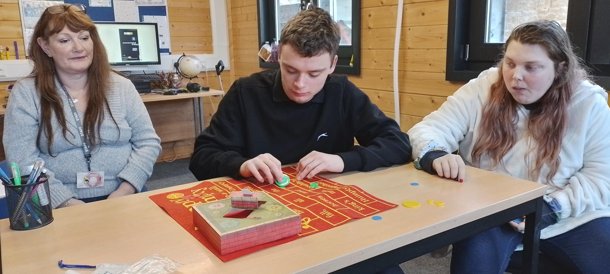 two ema students and one tutor playing a game in an ema gillingham campus classroom